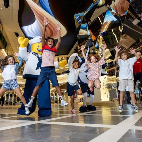 Family smiling and playing together on the open deck of an MSC Cruises ship, enjoying onboard activities.