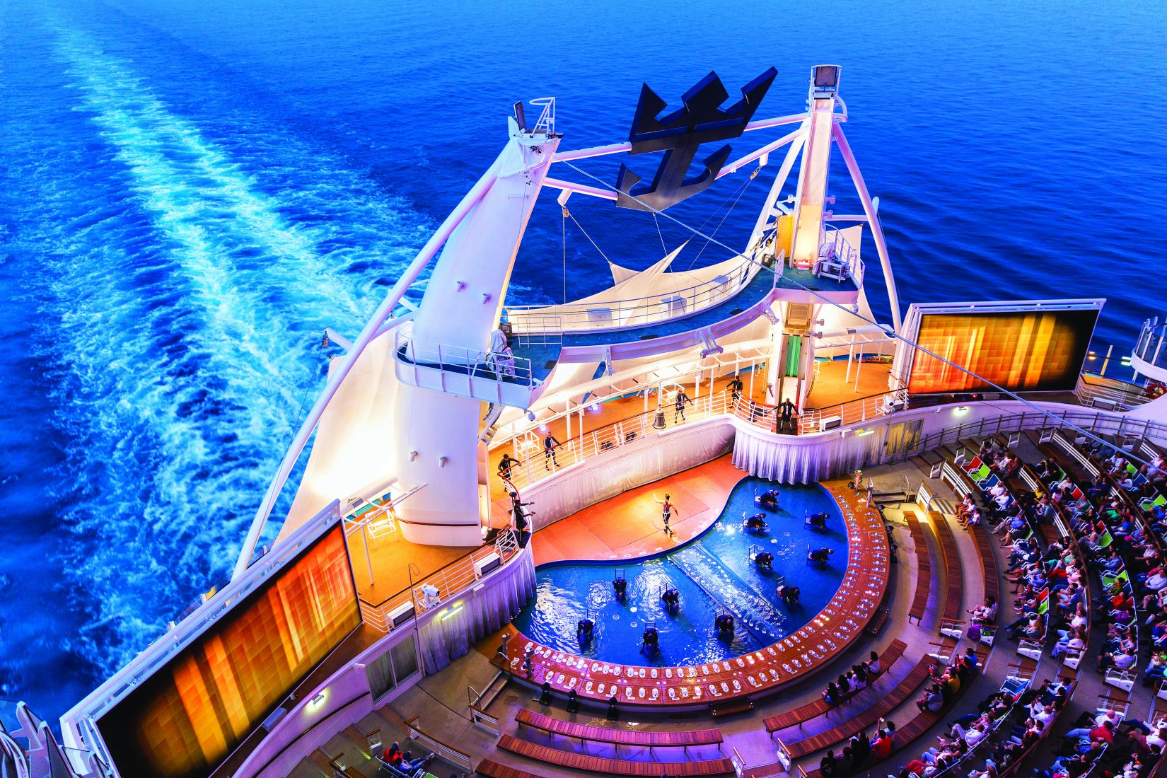 Dazzling outdoor water show at the AquaTheater on Royal Caribbean, featuring high dives, acrobatics, and stunning ocean backdrops.
