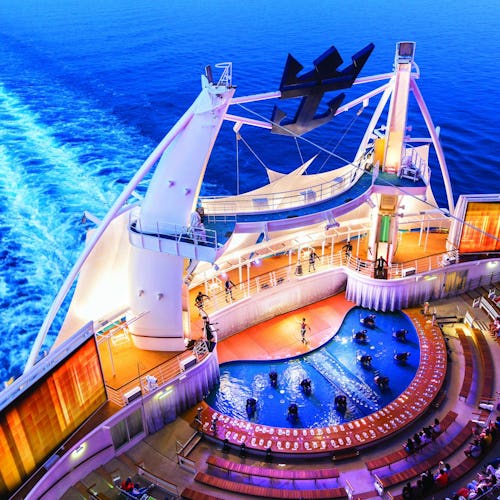 Dazzling outdoor water show at the AquaTheater on Royal Caribbean, featuring high dives, acrobatics, and stunning ocean backdrops.