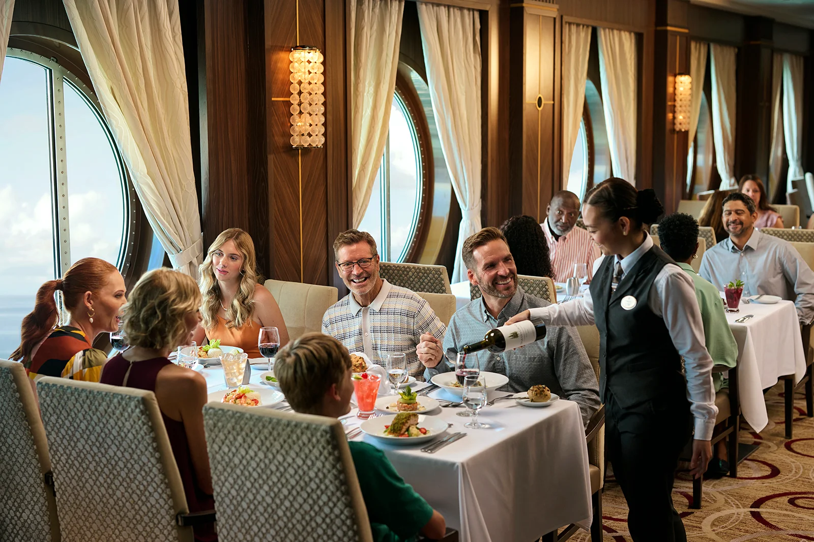  Guests enjoying a fine dining experience onboard Royal Caribbean, with expertly crafted cuisine and elegant oceanview surroundings.