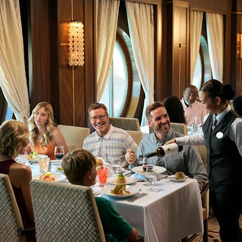 Guests enjoying a fine dining experience onboard Royal Caribbean, with expertly crafted cuisine and elegant oceanview surroundings.