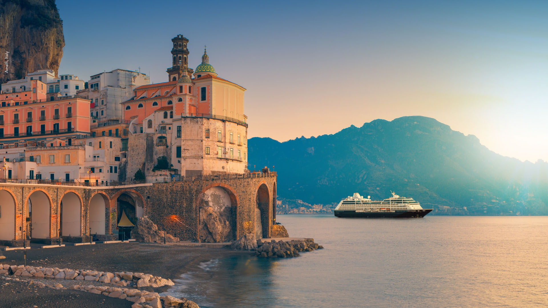  Azamara ship sailing near a charming European port, offering immersive destination experiences and boutique-style cruising.