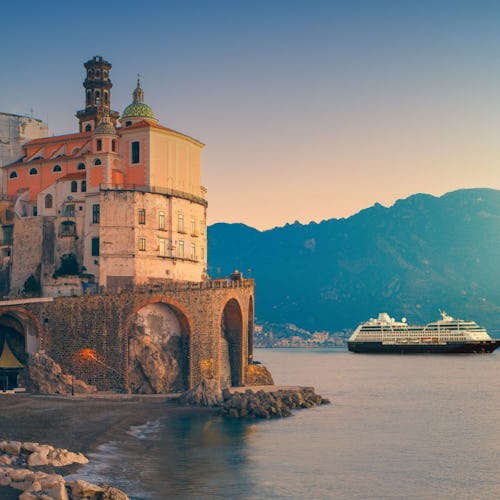 Azamara ship sailing near a charming European port, offering immersive destination experiences and boutique-style cruising.