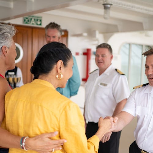 Azamara Captain warmly welcoming guests onboard, highlighting the line’s personalised and intimate service style.