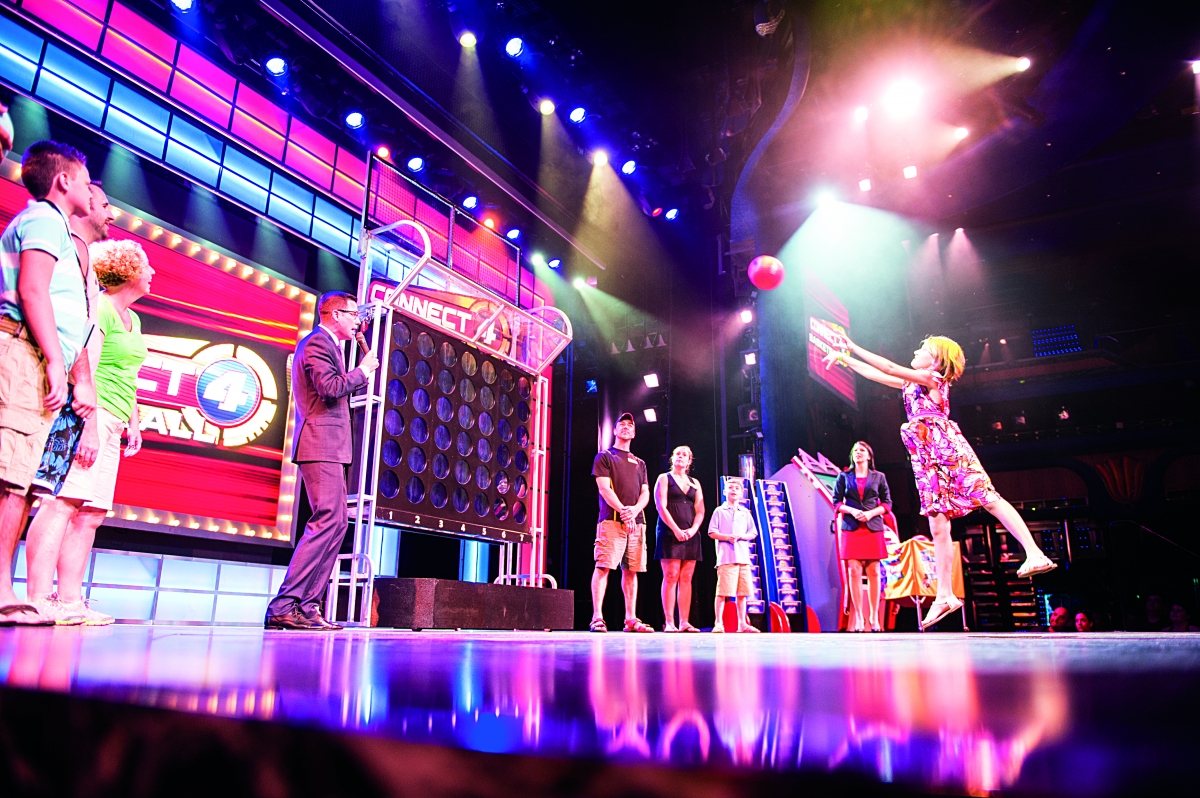 Guests enjoying a live comedy show aboard Carnival Cruise Line, with vibrant nightlife and entertainment options