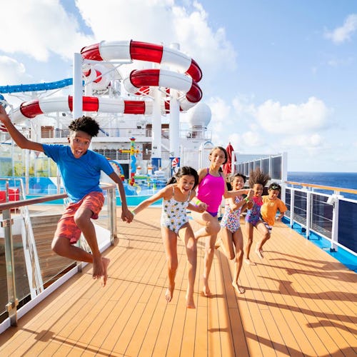 Family enjoying thrilling waterslides and splash zones on the top deck of a Carnival Cruise ship, making memories at sea