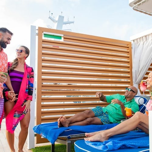 Guests unwinding in a quiet deck area aboard Carnival Cruise Line, with loungers, ocean views, and a laid-back atmosphere