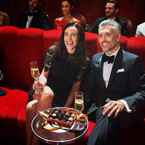 Couple enjoying a live performance in the Royal Court Theatre aboard Cunard, experiencing world-class entertainment at sea.